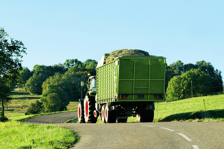 traktor z zieloną przyczepą